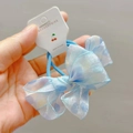 Detail of light blue polka dot bow hair tie with translucent organza texture on packaging - Blue Hair Rings (Pair)