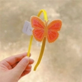 Detailed view of yellow headband with large orange glitter butterfly decoration - Rose Yellow Butterfly