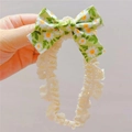Détail du bandeau bébé à nœud floral avec dentelle blanche et motif imprimé de marguerites - Vert olive
