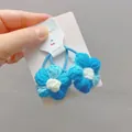Detailansicht handgehäkelter Blumen-Haargummis in Blau und Weiß auf Trägerkarte - Ein Paar / Verlauf Blau