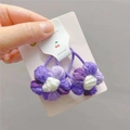 Detailaufnahme handgehäkelter Blumen-Haargummis aus violetter und weißer Wolle - Ein Paar / Farbverlauf Lila