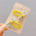 Detail of yellow fabric-wrapped hair clips with white lace and floral embroidery - Yellow