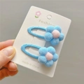 Close-up of blue plush flower hair clips with pink centers on a fashion display card - Light Blue BB Clip