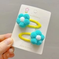 Detail of blue plush flower hair clips with yellow snap bases on a display card - Aqua Green BB Clip