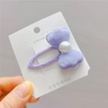Dettaglio del fermaglio per capelli con fiocco di peluche viola e perla sulla carta - Viola