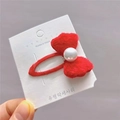 Macro d'une pince à cheveux nœud en peluche rouge avec perle sur carte blanche - Rouge