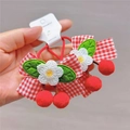 Detail of red gingham bow hair tie with crochet flower and plush cherry pom-pom charm - Flower Bow Hair Ties (Pair)