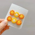 Handmade crochet flower hair clips for girls in vibrant orange and yellow daisy design - Orange + Yellow