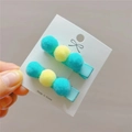 Detailed view of handmade plush ball hair clips in green and yellow for girls - Aqua Green and Pale Yellow Pair