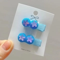 Detailed view of hair clips with blue pompoms and purple sequin flowers on cards - Lake Blue Style