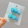 Detail of blue pompom hair clips with white sequin flowers for girls on a card - Aqua Green Style