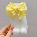 Dettaglio del fermaglio per capelli con fiocco giallo e pompon di pelliccia - Molletta Nappa Giallo Pallido