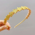 Close-up of sparkling gold sequin stars on a princess headband for girls and children - Gold Star Style