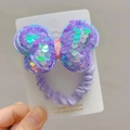 Dettaglio di un elastico per capelli con fiocco di paillettes viola su cartoncino - Viola