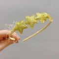Détail d'un serre-tête doré avec étoiles pailletées et décorations en dentelle - Or