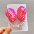 Close-up of pink sequin bow hair tie on a white retail display card for girls - Rose Red