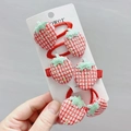 Detail of sequined strawberry hair clips and elastics on display card in hand - Red