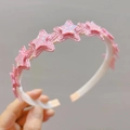 Nahaufnahme von rosa Glitzersternen auf Stirnband mit weißem welligem Innengriff - Dunkelrosa