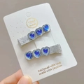 Nahaufnahme der herzförmigen blauen Edelstein-Haarklammern mit silbernem Glitzer-Finish - Königsblau (Paar)