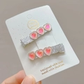 Close-up of two silver glitter hair clips with pink crystal hearts on a white card - Rose Red (Pair)