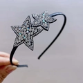 Close-up of dual rhinestone star decorations on a sleek black fabric-wrapped headband - White Star Duo Headband