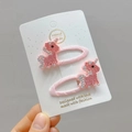 Close-up of pink unicorn hair clips with sparkling rhinestones on fabric base - Pink Rhinestone Unicorn