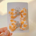 Détail de pinces à cheveux nśud fleuri avec couronne en argent et strass - Orange