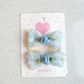 Dettaglio di fermagli per capelli in pizzo azzurro con rose di raso e foglie verdi decorate - Blu + Rosa Blu