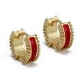 Detailed close-up of golden C-shaped huggie earrings with red enamel and radial texture - Red