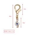 Détails porte-clés clé de sol doré avec émail blanc et œil bleu sur fond blanc - Style Note Clef de Sol (BE1369GD07)