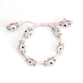 Detailed macro view of pink woven Evil Eye bracelet with sparkling rhinestone spacers - Pink