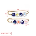 Detail view of gold-plated safety pins with blue evil eye beads and colorful resin flower charms - Transparent Flower Style (BE1732MI05)