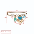 Détail d'une broche bébé dorée avec perles, œil protecteur et pendentif biberon vert menthe - Biberon Vert Menthe + Pieds Cœur Bleu + Mauvais Œil Bleu/Blanc (BE1746MI12)