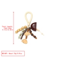 Detailed view of handmade ethnic keychain with natural seed shells and wooden beads - Earth Tone Braided Handle Pendant (6)