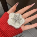 Dettaglio del fermaglio a fiocco di neve con strass luminosi e una perla bianca centrale - Stile Fiocco di Neve
