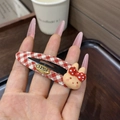 Detail of a red plaid BB hair clip with a cute resin 3D bunny and metallic snap closure - Red
