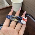 Detail of blue plaid fabric hair clip with a cute 3D resin rabbit and gold metal tag - Blue