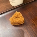 Dettaglio di un fermaglio per capelli a triangolo marrone in lana su vassoio di legno - Colore caramello