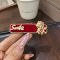Makroaufnahme einer roten Samt-Haarklammer mit Strasssteinen und goldenem Pferde-Charm - Schmaler Clip - Cai Pferd