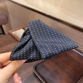 Dettaglio macro di un fermaglio per capelli in tessuto nero con motivo a pois bianchi - Nero