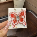 Détail d'une pince à cheveux papillon rouge brodée avec gland et strass en cristal - Papillon Unique / 1 Pièce / Papillon Rouge