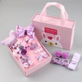 Macro-opname van roze haarspeldjes set voor kinderen met strikken en bloemen in een geschenkdoos - Paars