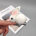 Gros plan d'une pince à cheveux lapin en peluche blanche avec oreilles roses et clip noir - Barrette Blanche