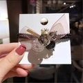 Détail d'un chouchou élastique avec nœud en maille rose et perles sur carte de présentation - Vert