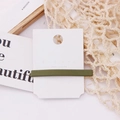 Detailed view of an olive green matte hair clip displayed on a minimalist white card - Green