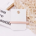 Close-up of matte pink rectangular hair clip on a branded card with aesthetic background - Pink