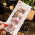 Detail of four-piece handmade kids hair clip set with pink bows and plush pom-poms - Mini Bowknot Necklace