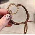 Detail eines braunen elastischen Haargummis mit runden Kunstperlen und goldener Basis - Rund Kaffee