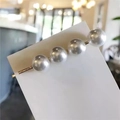 Macro detail of four white pearls on a gold hair clip set on a white display card - Simple Four Large Pearls Row Clip (AB-28-13)