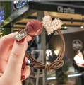 Detalle de un coletero marrón elástico con un corazón de perlas y una cuenta de resina lila - Rojo Caqui